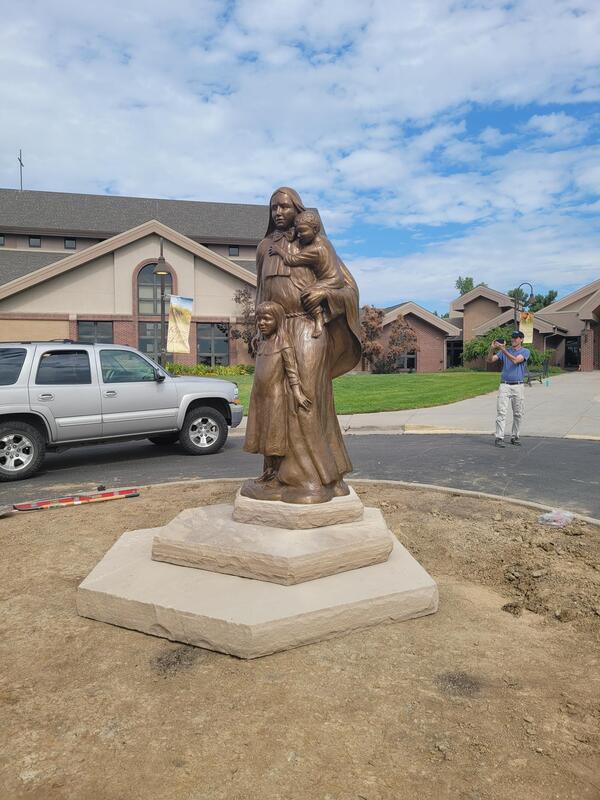 Just completed our installation of Gary Alsum's bronze "Mother Cabrini" at the Immaculate Conception Catholic Church vehicular entry located on Cabrini Drive in Lafayette, Colorado. UPDATE 2/18/21: Gary Alsum and the National Sculptors' Guild were selected to sculpt Mother Cabrini for the Immaculate Conception Catholic Church vehicular entry located on Cabrini Drive in Lafayette, Colorado.  Gary elected to depict Mother Cabrini, (also known as Saint Frances Cabrini), with children to show the nun's lifelong dedication to helping the poor, the sick, immigrants and those less fortune; forming schools and orphanages around the world in the late 1800's.  The bronze sculpture will be 8-ft tall, mounted on a trio of off-set hexagonal sandstone for an overall height of 11-12-feet. A natural pathway will be laid to allow visitors to experience the sculpture's details. We anticipate installation in late-Spring 2021.   About Cabrini...  The youngest of thirteen children, Frances Cabrini was born on July 15, 1850 in a small village called S’ant Angelo Lodigiano near the city of Milan, Italy. She grew up enthralled by the stories of missionaries and made up her mind to join a religious order. Because of her frail health, she was not permitted to join the Daughters of the Sacred Heart who had been her teachers and under whose guidance she obtained her teaching certificate.  However, in 1880, with seven young women, Frances founded the Institute of the Missionary Sisters of the Sacred Heart of Jesus. She was as resourceful as she was prayerful, finding people who would donate what she needed in money, time, labor and support. She and her sisters wanted to be missionaries in China; she visited Rome to obtain an audience with Pope Leo XIII. The Pope told Frances to go “not to the East, but to the West” to New York rather than to China as she had expected. She was to help the thousands of Italian immigrants already in the United States.  In 1889, New York seemed to be filled with chaos and poverty, and into this new world stepped Mother Frances Cabrini and her sister companions. Cabrini organized catechism and education classes for the Italian immigrants and provided for the needs of the many orphans. She established schools and orphanages despite tremendous odds.  Soon, requests for her to open schools came to Frances Cabrini from all over the world. She traveled to Europe, Central and South America and throughout the United States. She made 23 trans-Atlantic crossings and established 67 institutions: schools, hospitals and orphanages.  Her activity was relentless until her death. On December 22, 1917, in Chicago, she died. In 1946, she was canonized a saint by Pope Pius XII in recognition of her holiness and service to mankind and was named Patroness of Immigrants in 1950.
