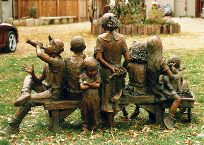 National Sculptors' Guild public art placement 36 Jane DeDecker's Snapshot multicultural figurative bronze sculpture Oxnard, California 1995 "Snapshot" by Jane DeDecker and the National Sculptors' Guild was placed in Oxnard, California in 1995.   ​Snapshot was originally commissioned by Michael Jackson, The multi-figure bronze depicts a number of children ready for the camera, sitting on a bench with a wagon pulled up to one side; the kids are in a casual pose, enjoying a respite from summer play, holding toys and drinking a soda. It even includes the pouting kid in the back - not wanting to be pictured as often happens. The piece is universal even though it was inspired by photos Jackson gave DeDecker.   NSG Public Art Placement 36