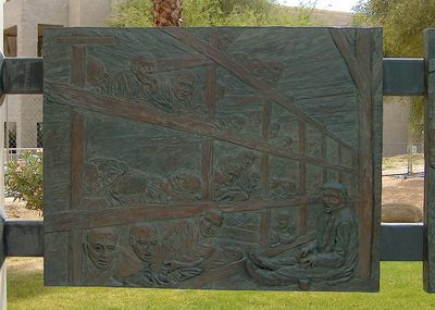 National Sculptors' Guild public art placement 27 The Desert Holocaust Memorial 1995 Memorial and Site Design by John Kinkade; Bronze sculpture by Dee Clements Palm Desert California The Desert Holocaust Memorial remains one of the National Sculptors' Guild's most important placements. We are so honored to be a part of this historic memorial that has provided a space for remembrance, education, and healing for people around the world since it's placement in Palm Desert, California in 1995. ​As you approach the Desert Holocaust Memorial, you see a circular row of trees. These trees represent life outside of the enclosed fence of the concentration camps. At the entry to the memorial you will see a bronze plaque which gives a chronology of the systematic deprivation by law of the civil rights, jobs, property and life of “non-Aryans” by the Nazi party. Inside the history pedestal is buried an urn containing the verified names of 12,000 Righteous Gentiles who hid or assisted those condemned by Nazi regime during the years of the Holocaust.  At the heart of the memorial are seven larger than life bronze figures representing the people and different aspects of the Holocaust. The standing man is intended to be defiant and accusing. He in part represents the resistance of the Jews and others that fought the Nazi tyranny. (Note the left forearm on this man bears the number tattooed on a local Holocaust survivor.)  The other figures are of a mother with two children begging for mercy, a boy from the ghetto, a rabbi praying, and finally the figure behind the group, a man alone, silent, dying. His death represents bigotry, ignorance, and hatred taken to its inevitable end.  The faces and representations at the memorial were taken from actual photographic and news footage researched by the artist's team at the United States Holocaust Museum in Washington D.C.  The seven bronze figures are mounted on a double-tiered Star of David 20 feet across. The block granite is etched with a map of Europe indicating the location of the many concentration camps as well as the number of persons who perished.  The cobblestone and light standards are replicas of those at Auschwitz. Placed between the light posts are eleven bas reliefs telling the story of the Holocaust. A plaque located adjacent to each details the specific scene represented. ​ This memorial includes extensive provisions for educating people of all ages, races, and religions about the period of the Holocaust. It is a lesson about denial of basic civil rights. The monument memorializes lost parents, children, loved ones, and millions of innocent people. It is a place of respect, of respite, of mourning and of remembrance. It is also a monument of hope -- hope that we can overcome bigotry and live among diversity in peace. -Desert Holocaust Committee.
