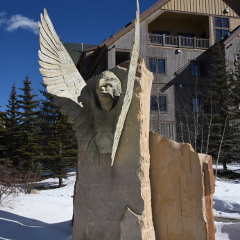 Denny Haskew and the National Sculptors’ Guild have completed and placed a one-of-a-kind monument titled “Whispers of Oneness” for Keystone, Colorado,  The 15-foot tall bronze and Dakota sandstone sculpture was dedicated in December, 1997.  A trans morphic depiction of a Ute Medicine Man enveloped by an eagle emerging from a stone monolith. The artwork honors the Utes and their 10,000 year history in Summit County.  For these multi-media works, Denny has developed a patina that matches the unique qualities of the stone, making the materials appear as one.  The artwork was selected from a national competition by The Summit Foundation and Keystone Real Estate Developments for placement at the River Run Events Plaza in Keystone, Colorado.  The NSG design team members for this placement were Denny Haskew, Sculptor, and John W. Kinkade, Executive Director, National Sculptors’ Guild, both of Loveland, Colorado.   Original Narrative from the Proposal: 