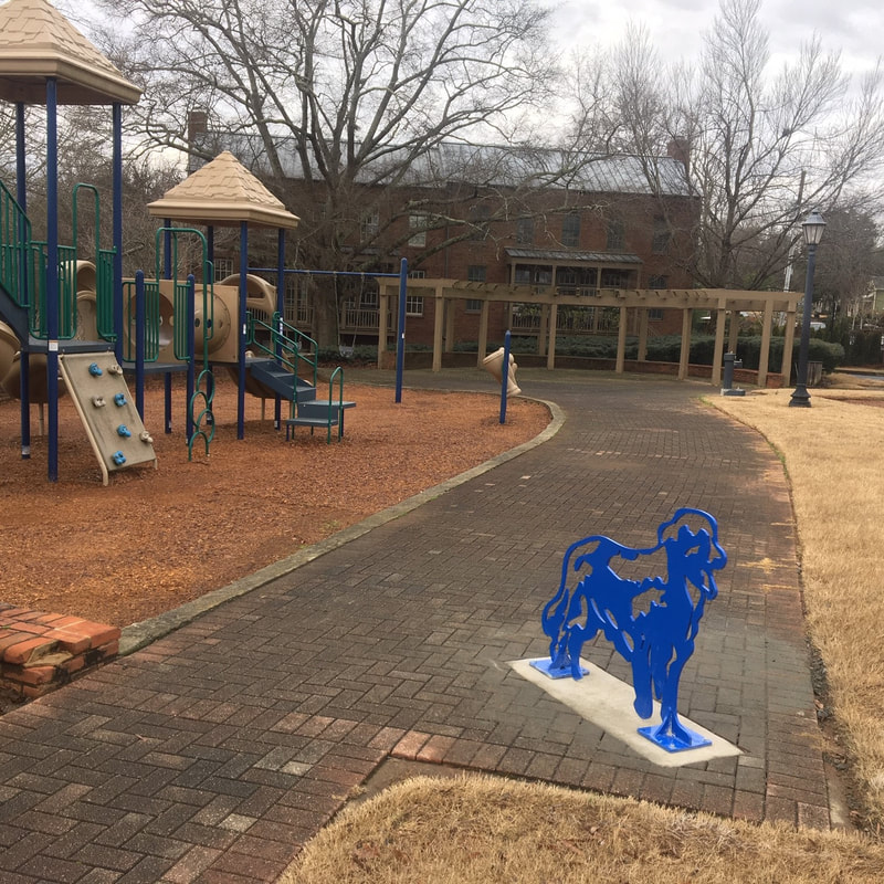 Golden Blue Guard Dog Bike Rack by Joe Norman and the National Sculptors' Guild placed in Roswell, GA, 2019. Features a Golden Retriever Dog cutout of Stainless Steel, painted royal blue. The dog can 