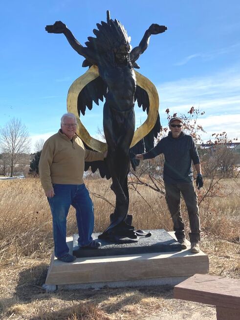 John Kinkade and Denny Haskew pose with sculpture Committed. The National Sculptors' Guild installed Charter Member, Denny Haskew's bronze sculpture 'Committed' at the Josephine B. Jones Park and Open Space in Greeley, Colorado this morning. The sculpture was donated to the site by NSG Director, John Kinkade, in honor of his parents, Jack and Ditto Kinkade, long-time, beloved residents of Greeley who frequently donated their time and services to the community.  Kinkade was instrumental in the creation of the park 30+years ago in the name of close family friend Josephine Jones, a true pioneer of the region who enriched the community in cultural events, historic preservation, and as an avid proponent of natural spaces;  many of the trees in the open space were planted as saplings by Jones.   The 11-ft tall bronze is enhanced with gold leaf on the sash. We've mounted the sculpture to a 1-ft tall sandstone base that is inscribed: 
